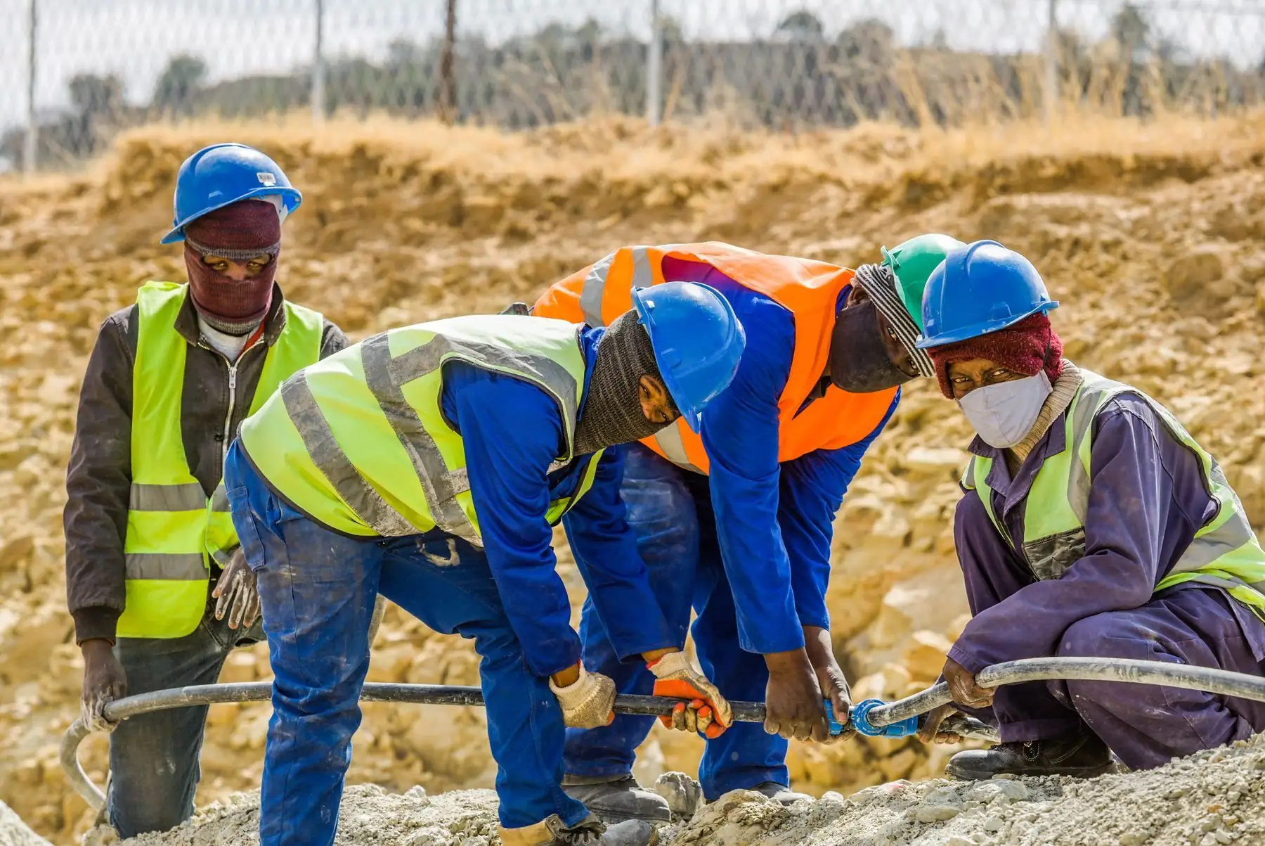 A site crew fitting a pipe joint on a South African construction site